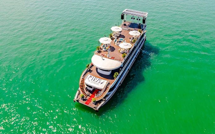 Luxury cruise ship Iris on Ha Long Bay, Vietnam, with sun decks and seating areas.