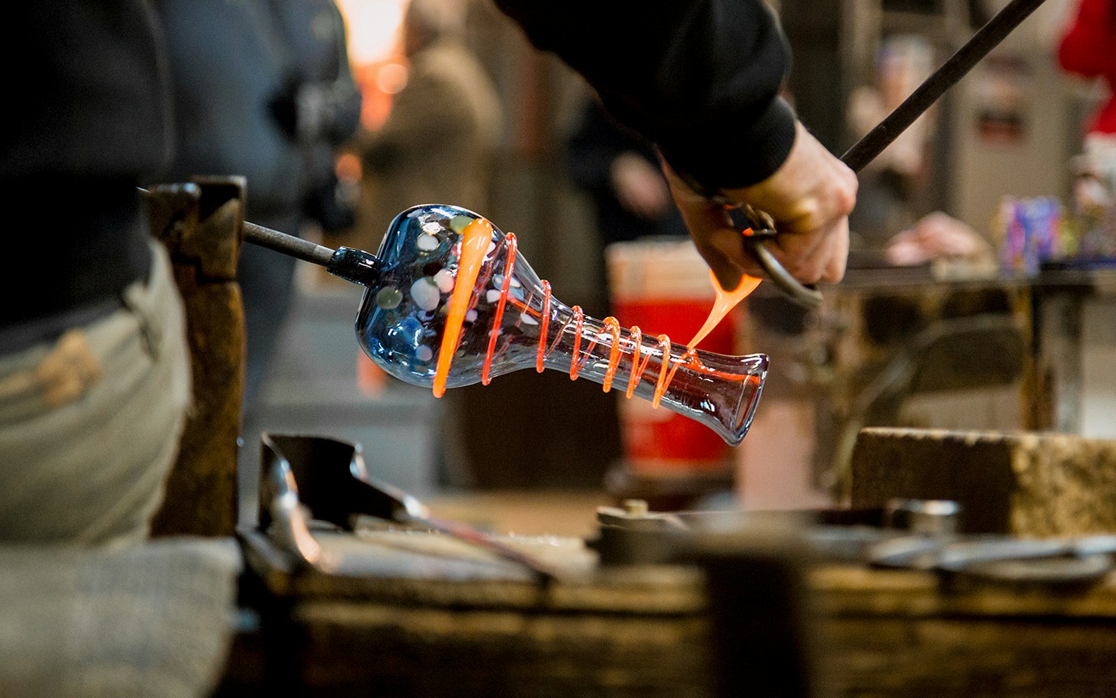 Artisan crafting glass vase in Murano, Italy.