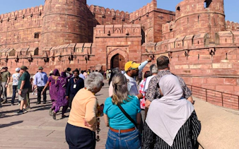 Tourists exploring Agra Fort with a guide during a private heritage tour in Agra.