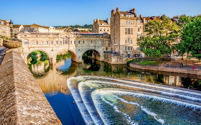 Pulteney Bridge over River Avon in Bath, England, with cascading weir in foreground.