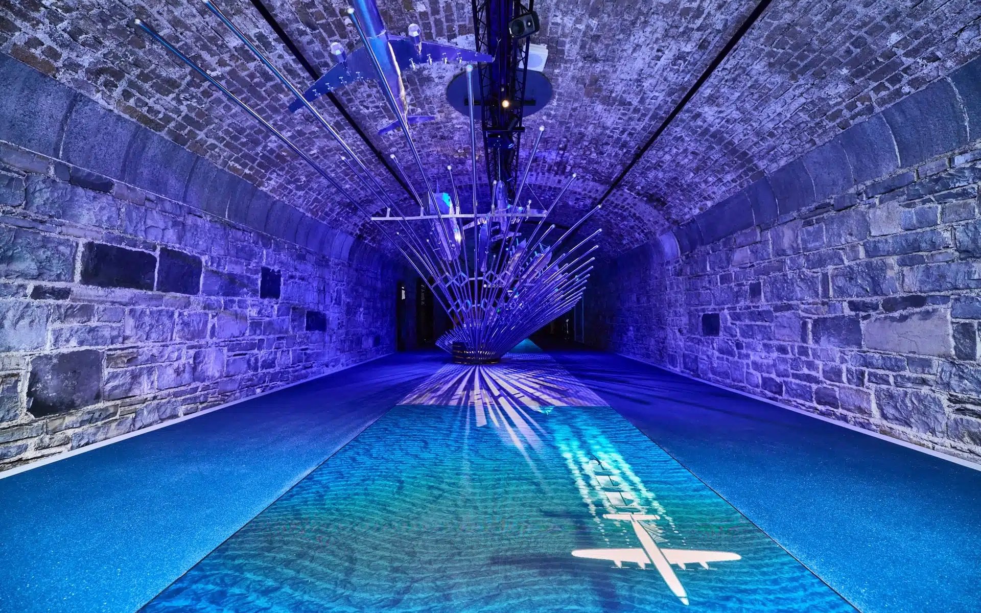 Futuristic installation with airplane projection in a stone tunnel at Epic Museum.