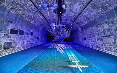 Futuristic installation with airplane projection in a stone tunnel at Epic Museum.