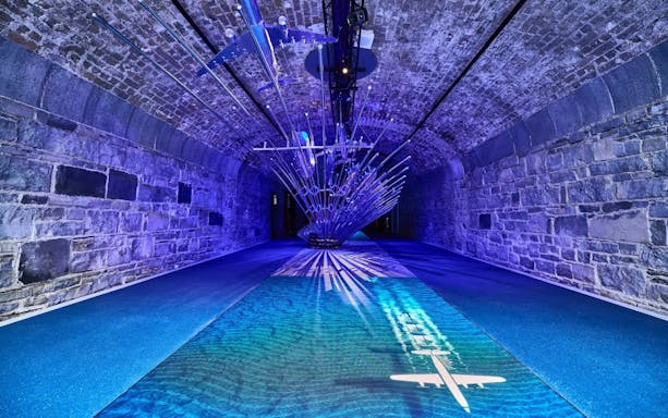 Futuristic installation with airplane projection in a stone tunnel at Epic Museum.