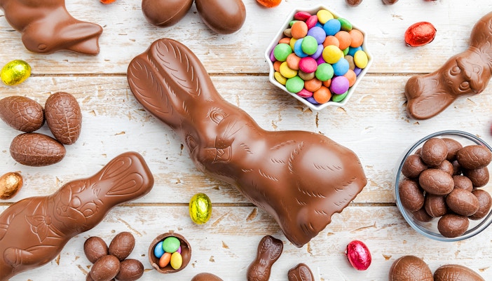 Chocolate Easter bunny and eggs on rustic wooden table.