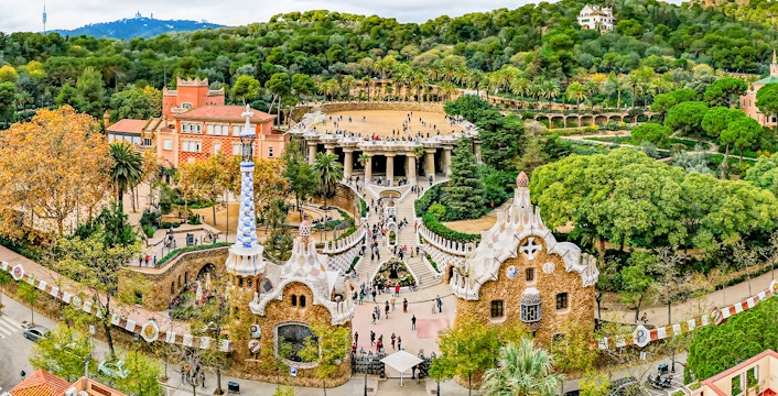 Park Guell entrance with colorful mosaic tiles and architectural details in Barcelona, Spain.
