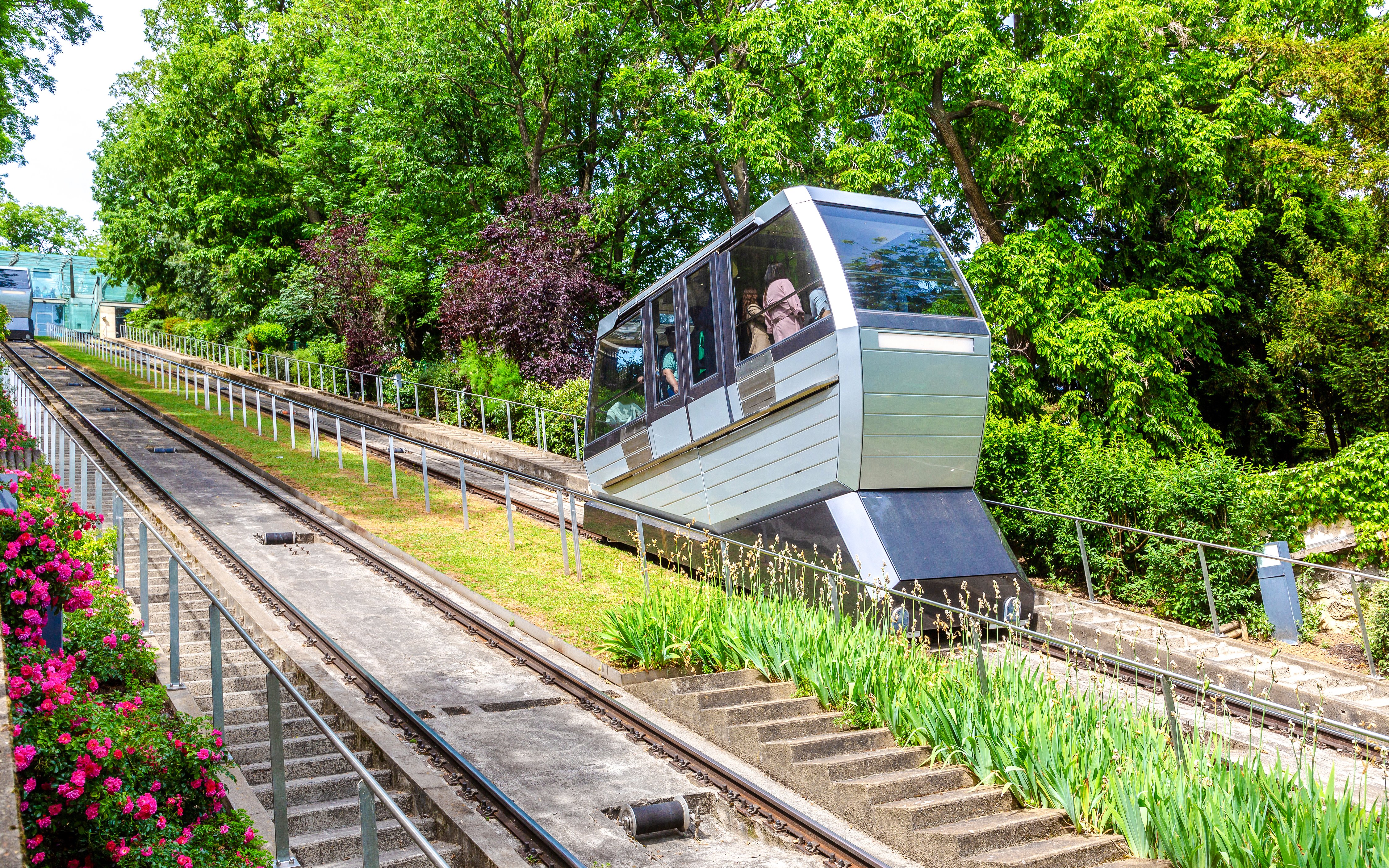 Montmartre funicular ascending through lush greenery in Paris.