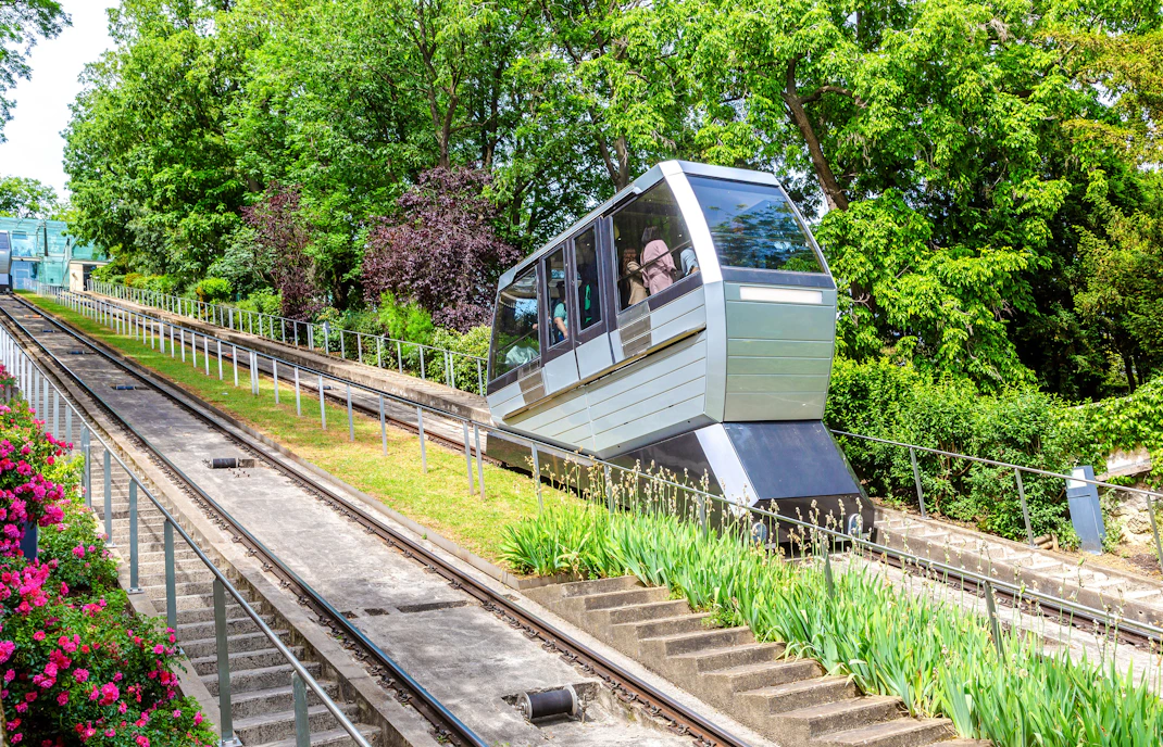 Montmartre funicular ascending through lush greenery in Paris.