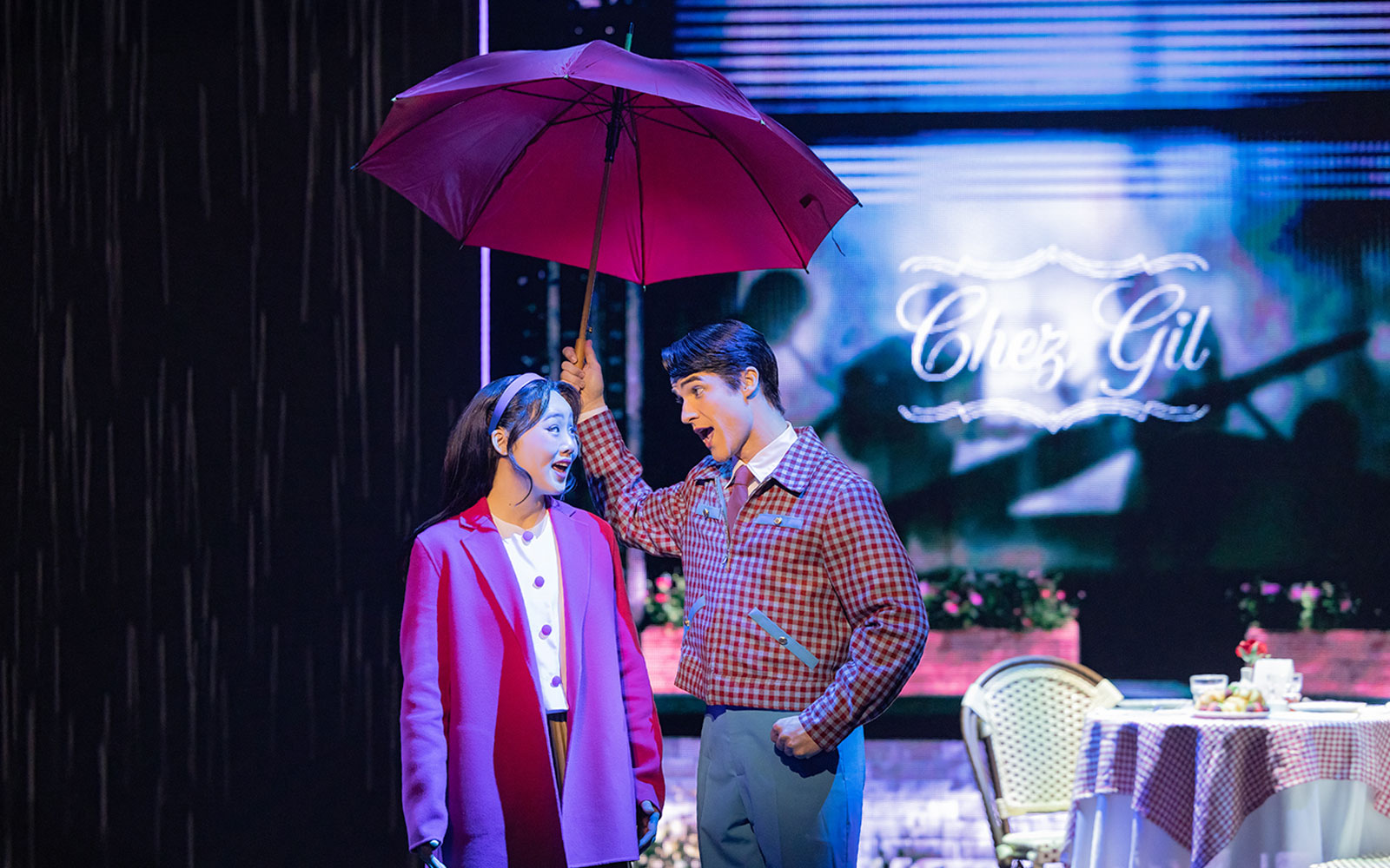 Actors performing Maybe Happy Ending on Broadway stage under an umbrella.