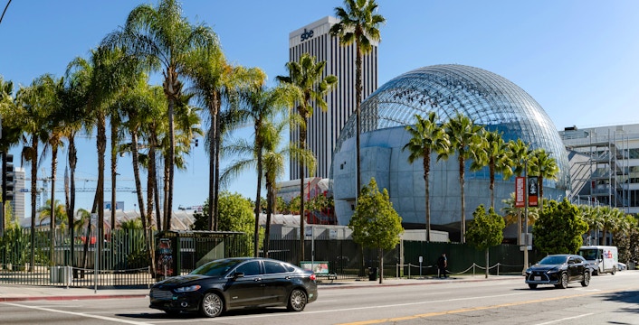 Academy Museum of Motion Pictures with palm trees and street view in Los Angeles.