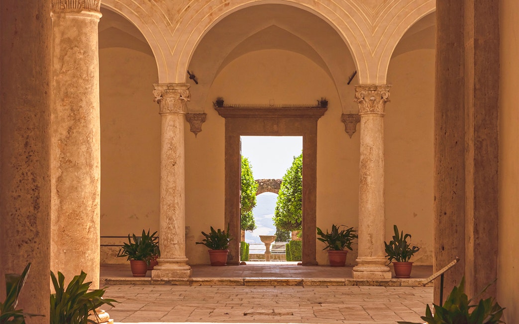 Courtyard view with stone columns at Palazzo Piccolomini, Italy.