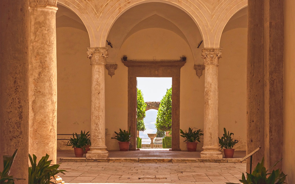 Courtyard view with stone columns at Palazzo Piccolomini, Italy.