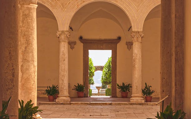 Courtyard view with stone columns at Palazzo Piccolomini, Italy.