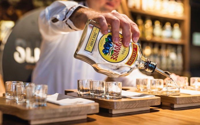 Pouring plum brandy into tasting glasses at Slivovitz Museum.