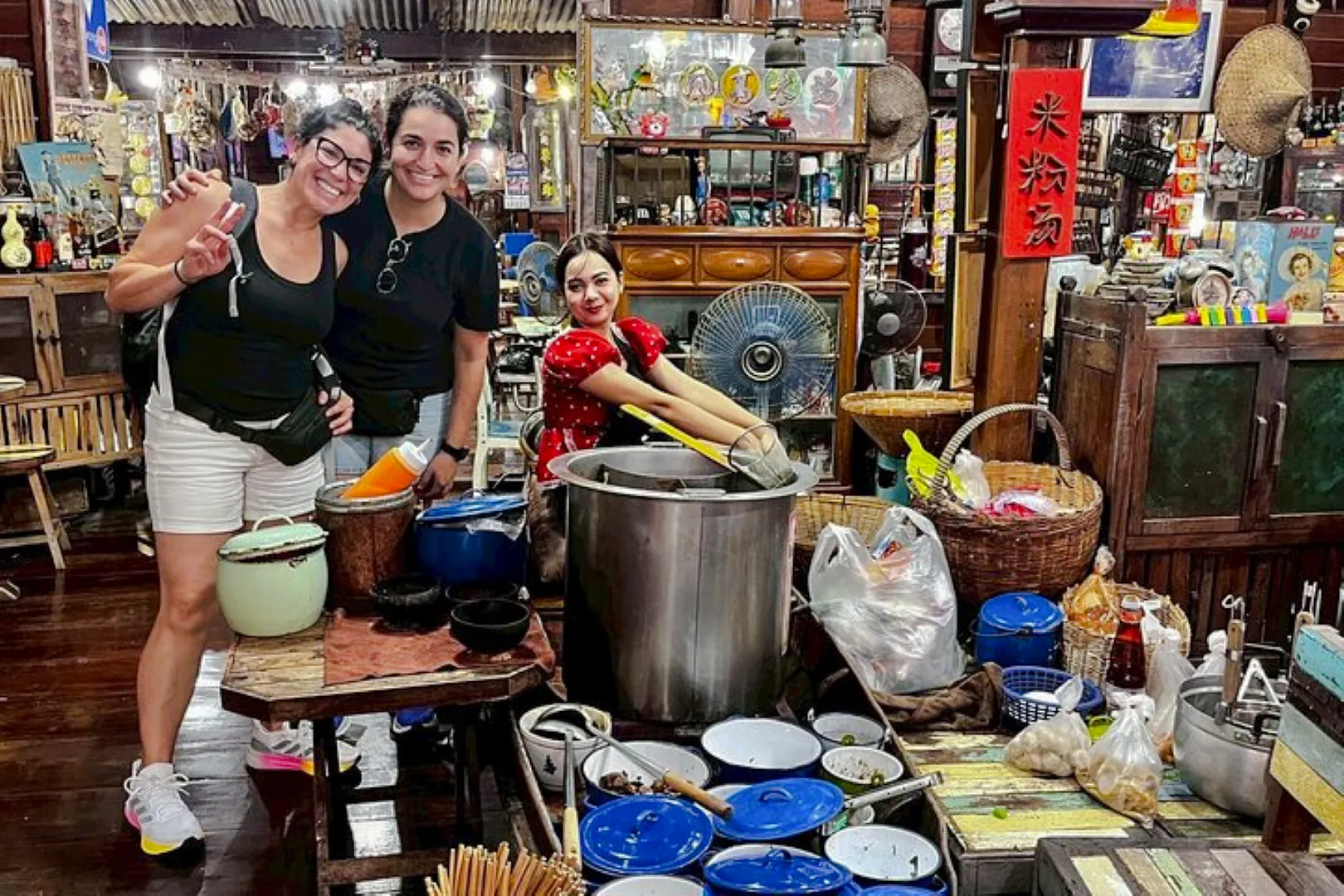 Visitors enjoying local cuisine at Amphawa Floating Market, Thailand, during a private shore excursion.