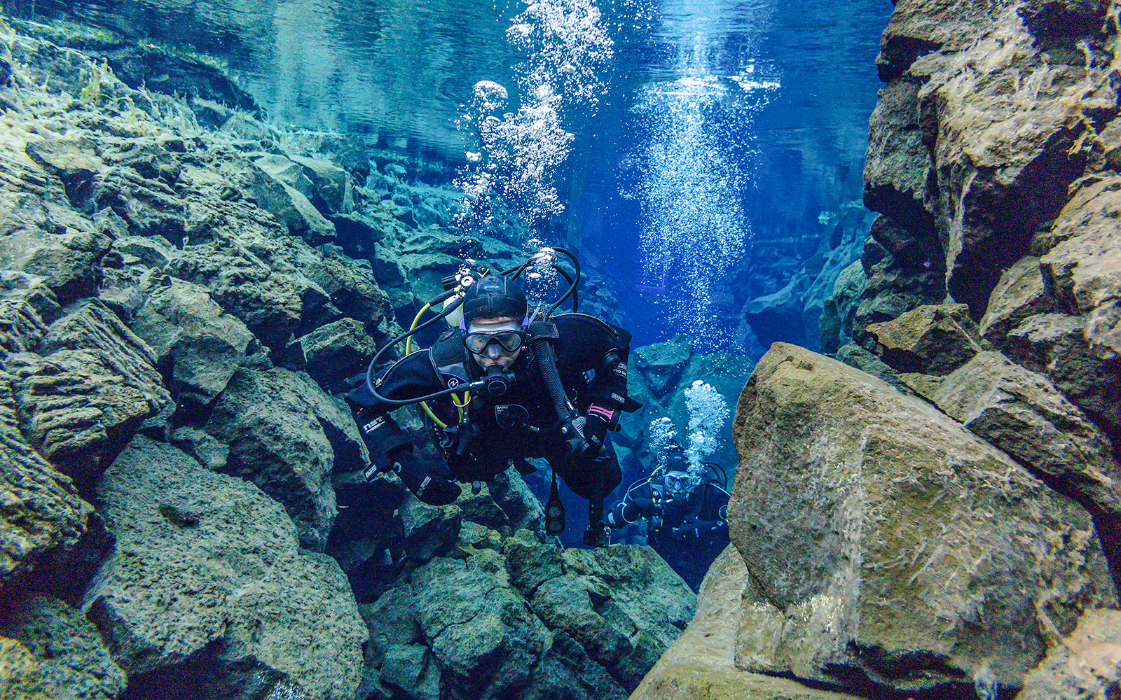 Snorkeler exploring Silfra Fissure's clear waters between tectonic plates in Iceland.