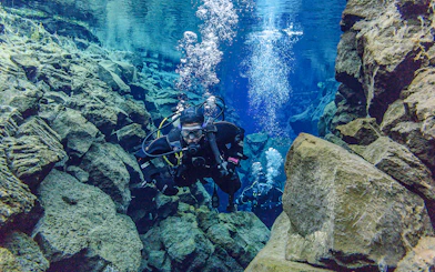Snorkeler exploring Silfra Fissure's clear waters between tectonic plates in Iceland.