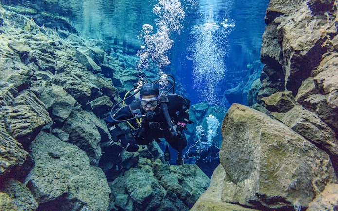 Snorkeler exploring Silfra Fissure's clear waters between tectonic plates in Iceland.