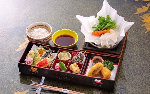 Traditional Japanese bento with rice, tempura, and vegetables on Kyoto Sagano Romantic Train Day Tour.
