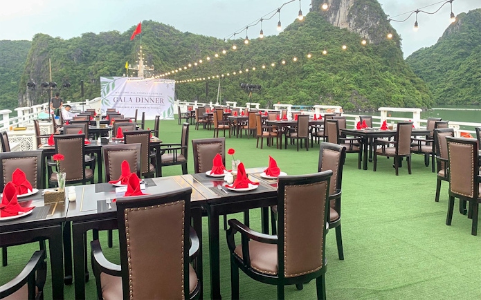 Outdoor dining setup on Starlight Cruise with scenic views of limestone cliffs.