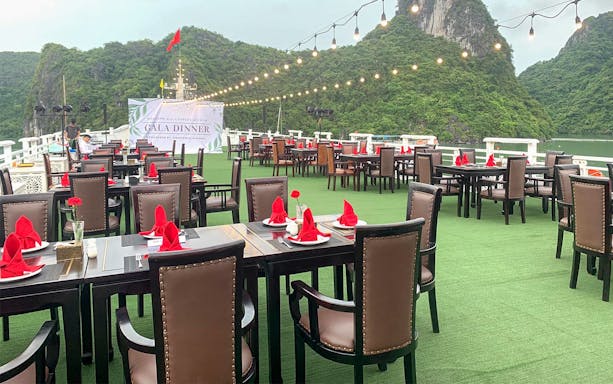 Outdoor dining setup on Starlight Cruise with scenic views of limestone cliffs.