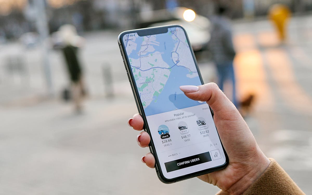 Hand holding phone displaying Uber app