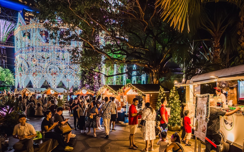 Festive huts and Christmas market at Gardens by the Bay, Singapore, with illuminated decorations.