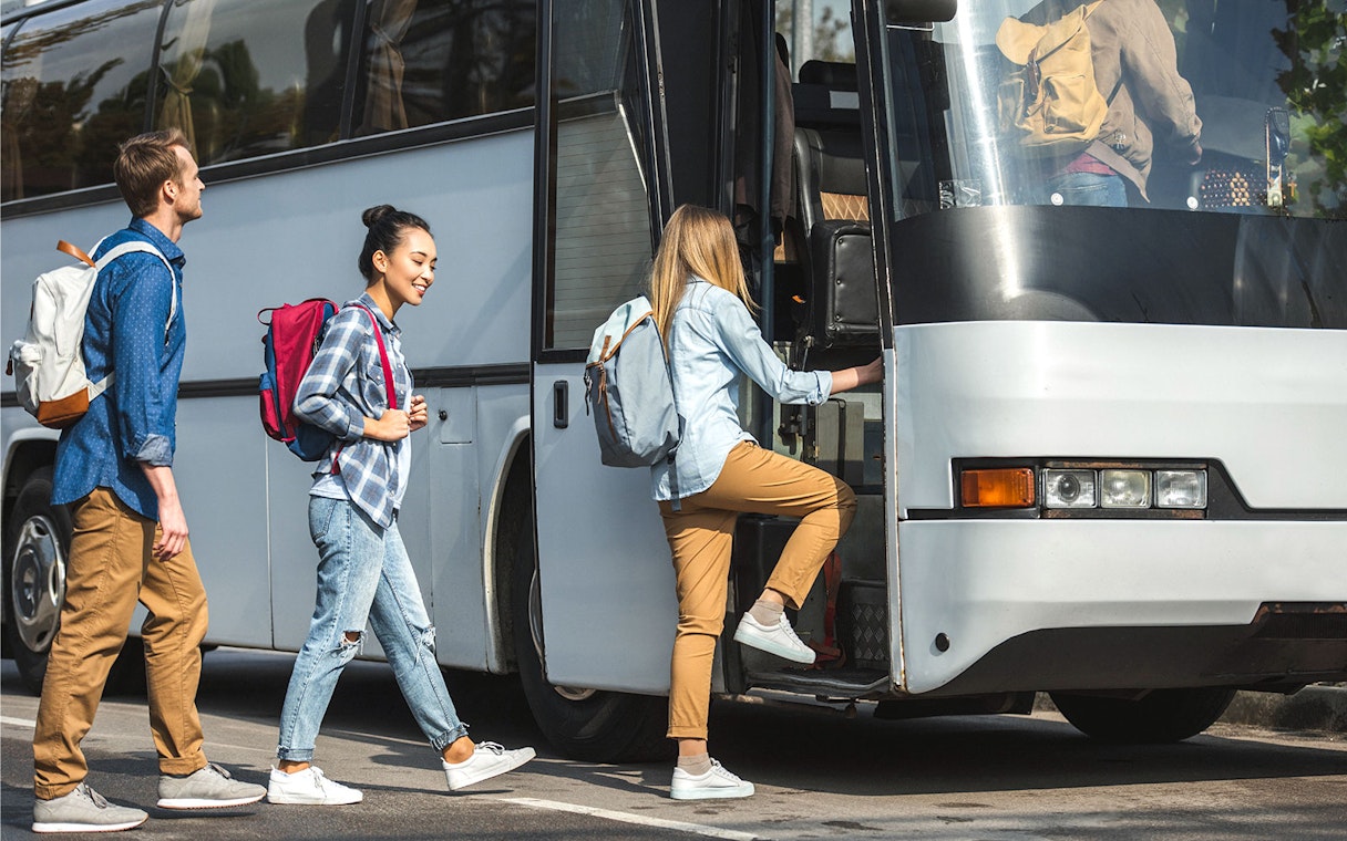 Travelers boarding a bus for shared transfer to Disney Resort Tokyo.