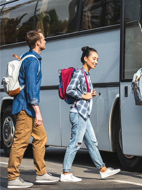 Travelers boarding a bus for shared transfer to Disney Resort Tokyo.