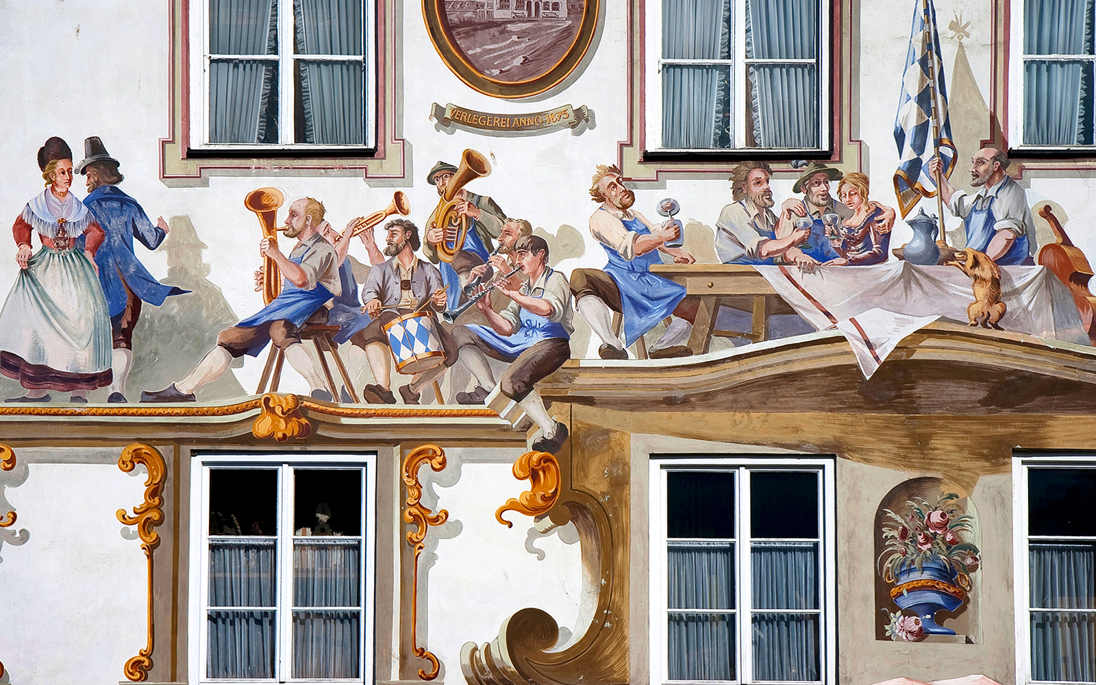 Bavarian mural depicting musicians and dancers on a building facade in Bavaria, Germany.