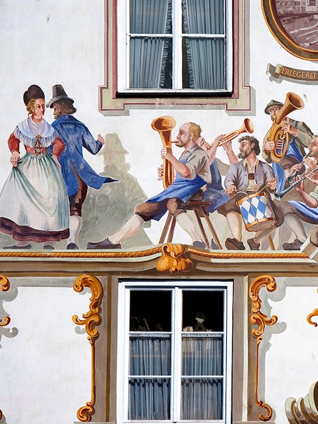 Bavarian mural depicting musicians and dancers on a building facade in Bavaria, Germany.