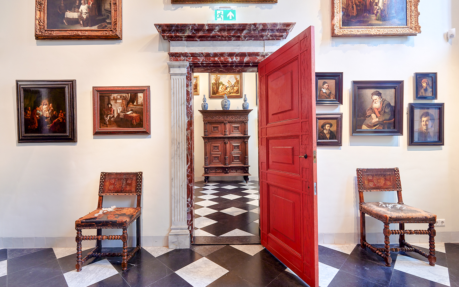 Rembrandt House Museum interior with paintings, red door, and antique furniture.