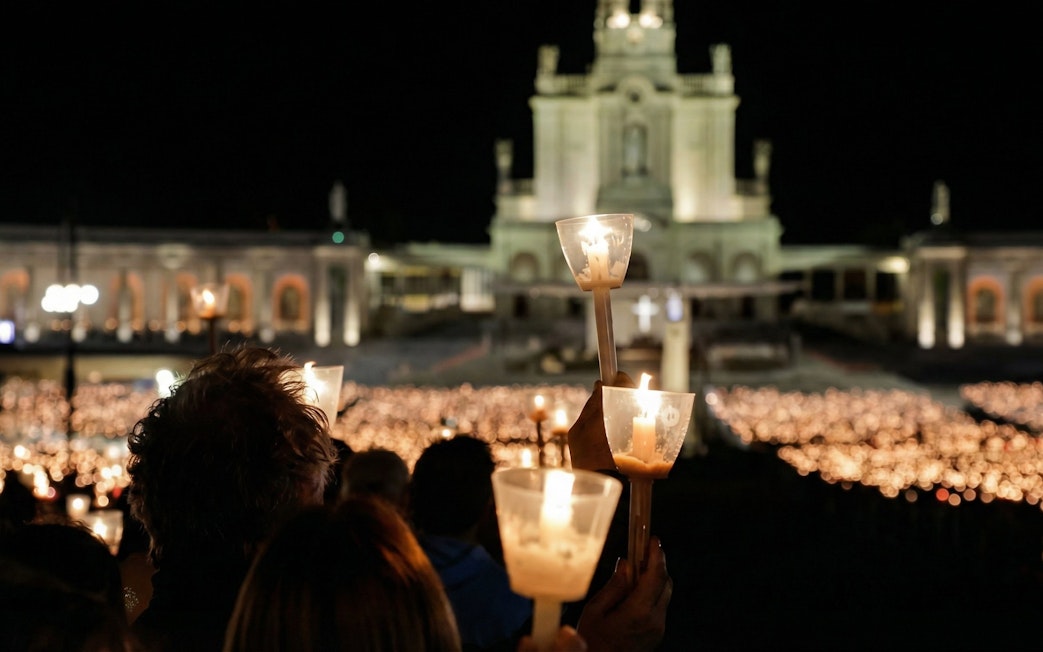 Candlelight procession at Fatima Sanctuary during night pilgrimage tour.