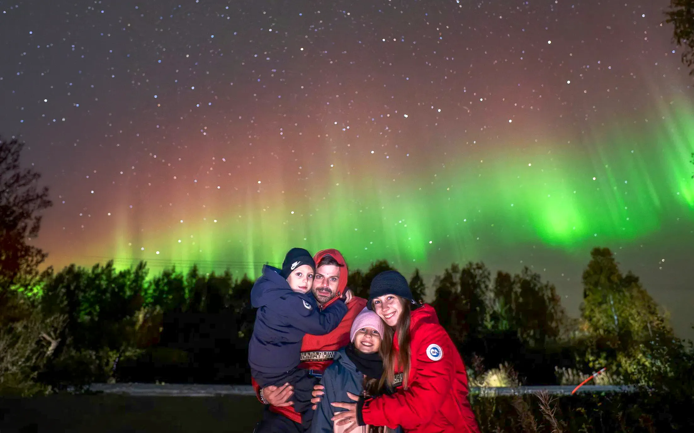 Family enjoying Northern Lights on a photography tour.