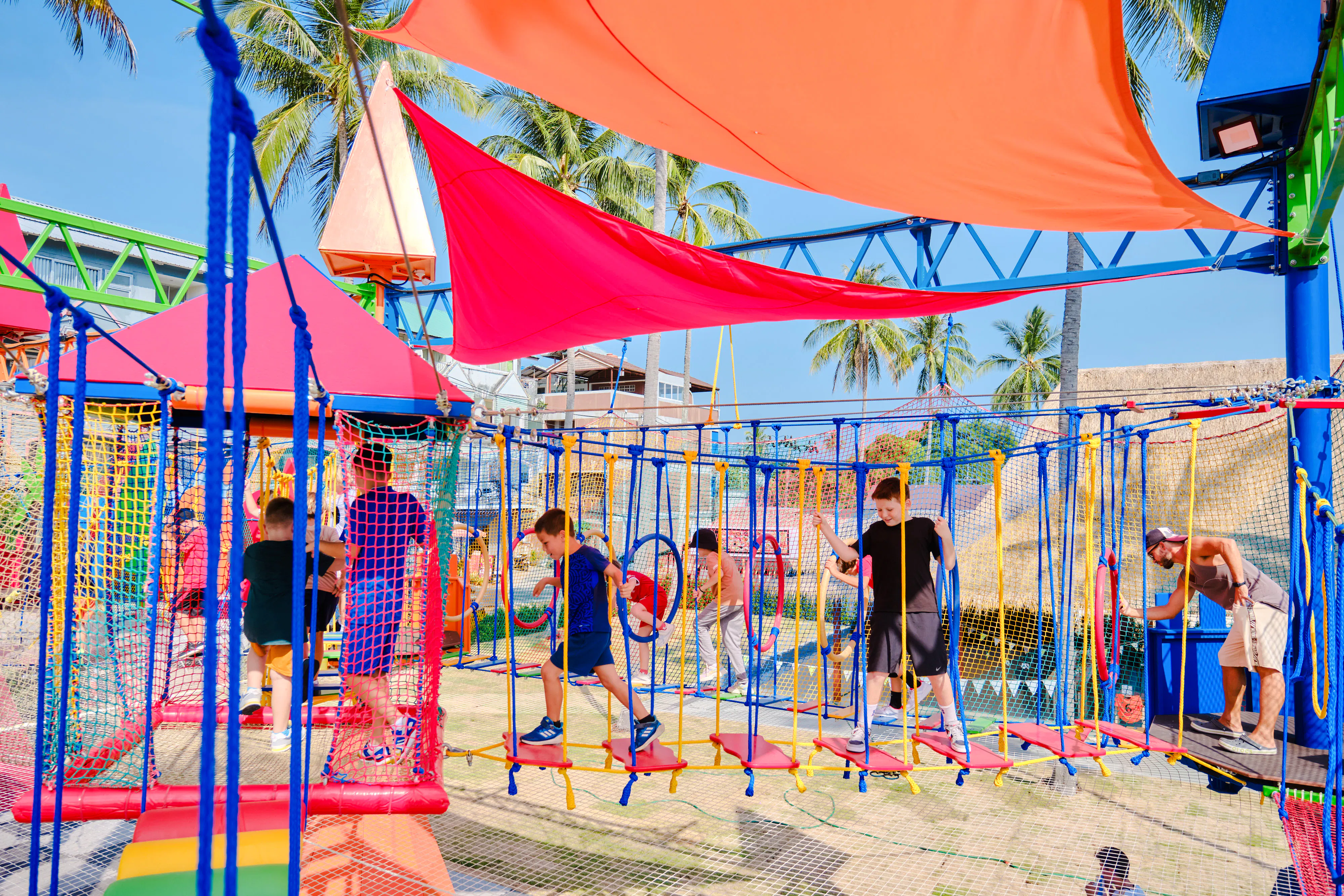 Children playing on a colorful rope course at Ko Fun Kids Park, Phuket.