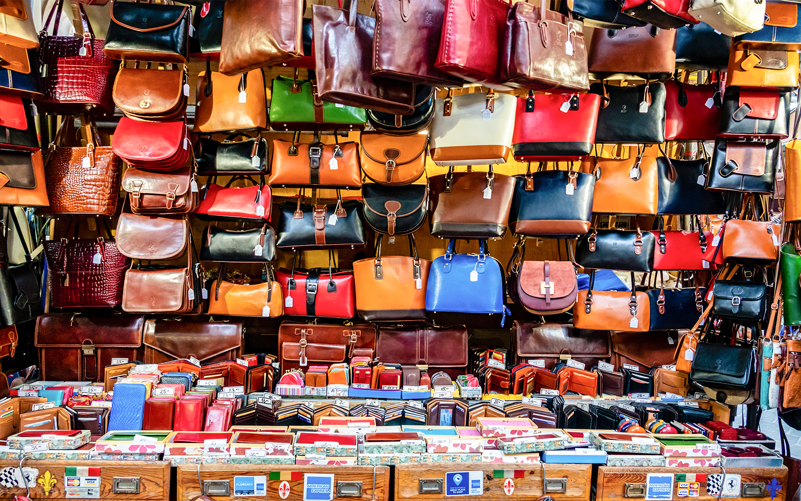 Leather bags and wallets displayed at a market stall in Florence, Italy.
