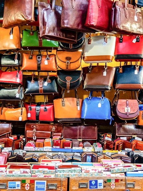 Leather bags and wallets displayed at a market stall in Florence, Italy.