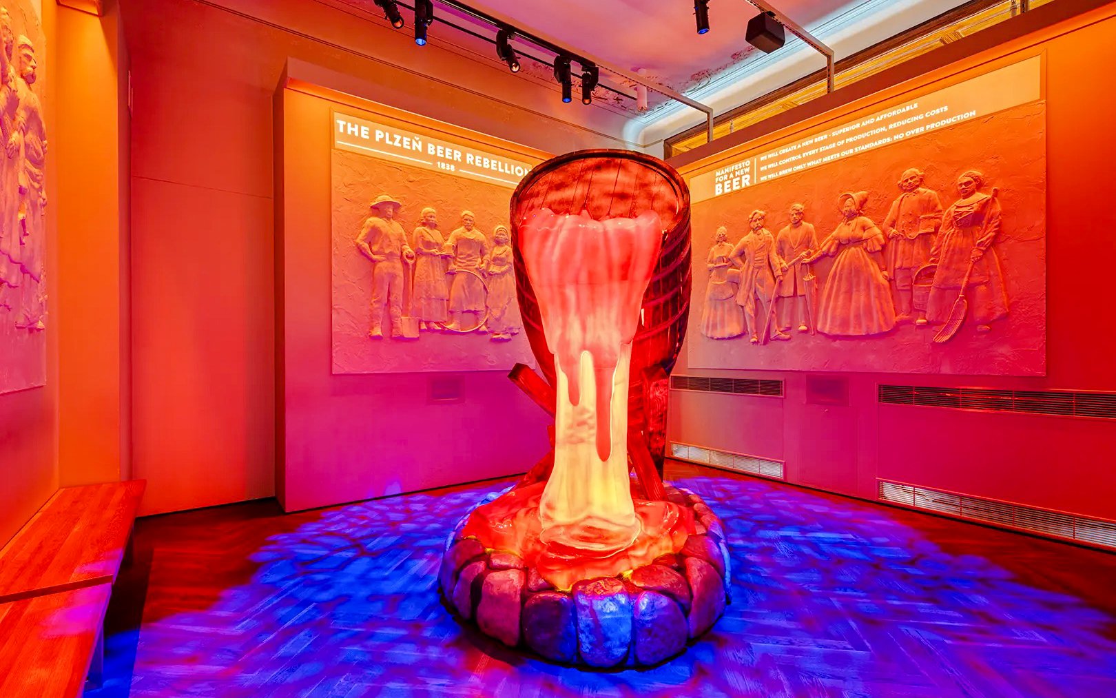 Pilsner Urquell exhibit in Prague showcasing beer history with illuminated sculpture.