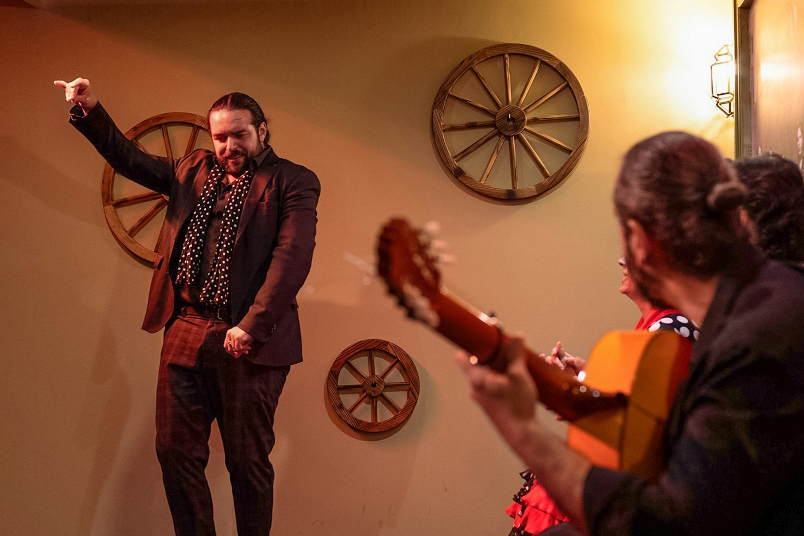 Flamenco dancer performing at Tablao La Cantaora in Seville with guitarist in foreground.