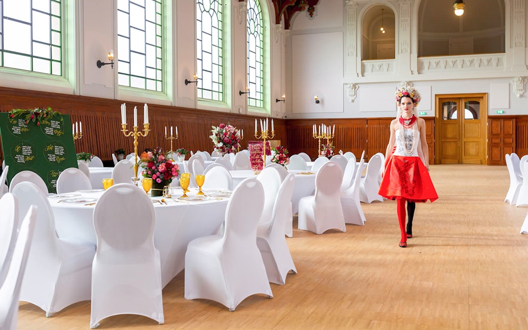 Hungarian Royal Guard exhibition hall with elegantly set tables and a performer in traditional attire.