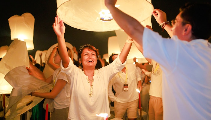 Couple releasing a sky lantern at Chiang Mai Sky Lanterns Festival, Thailand.