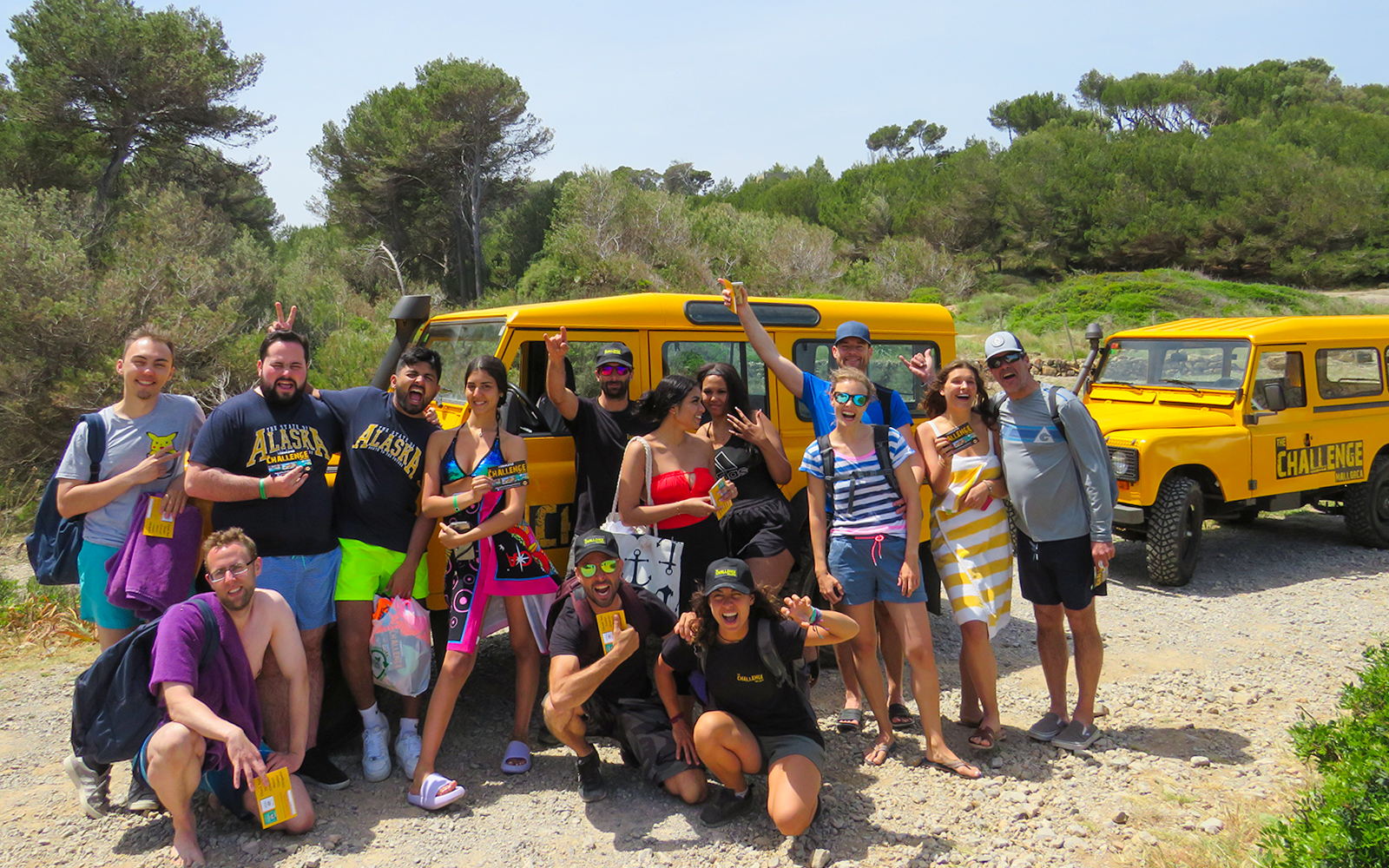 Group of tourists in front of yellow jeeps in Mallorca, ready for outdoor activities.