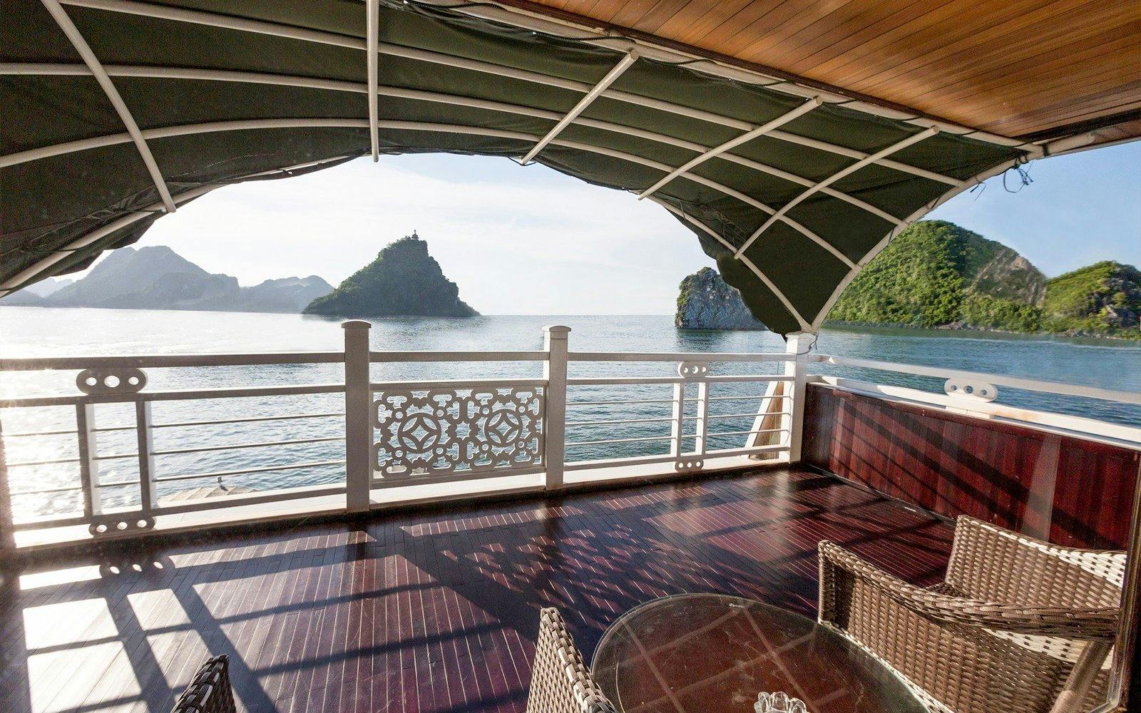 Starlight Cruise deck overlooking ocean and limestone islands in Halong Bay.