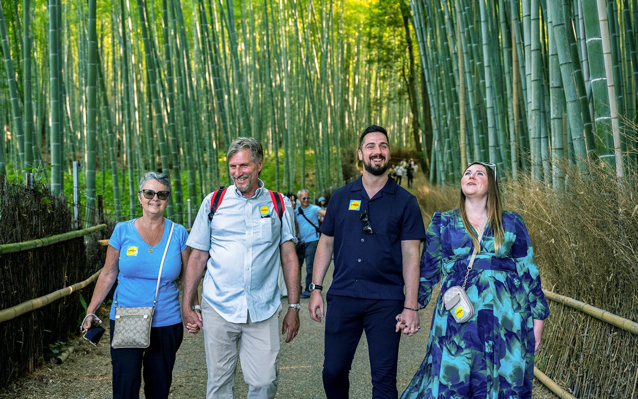 Tourists walking through Arashiyama Bamboo Grove on Kyoto Day Tour from Osaka Namba.