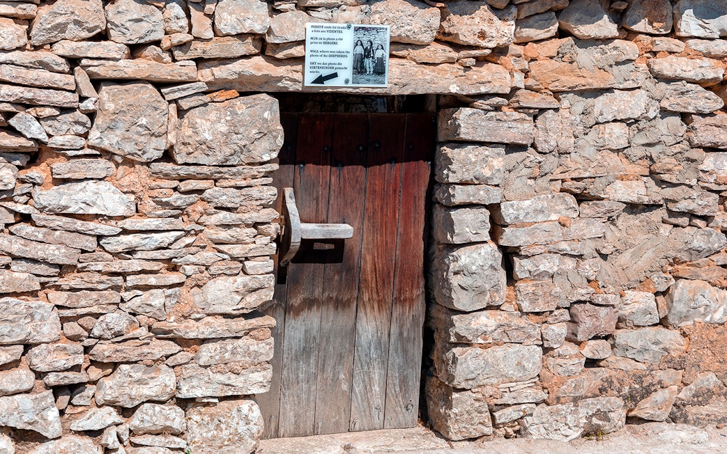 Stone doorway at a historical site in Fátima, Portugal, featured on the full-day tour from Porto.