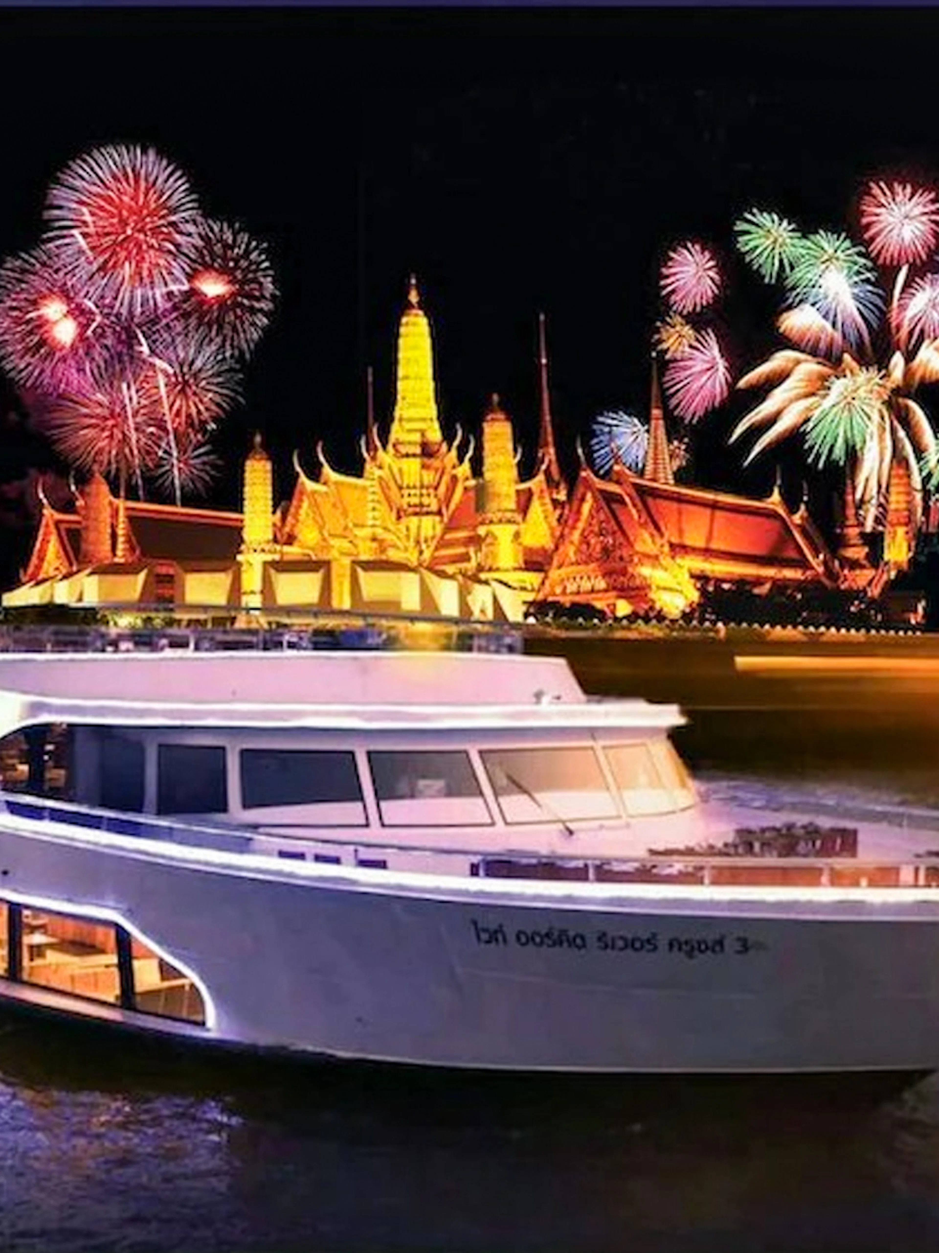 River cruise near illuminated Wat Arun with fireworks in Bangkok, Thailand.