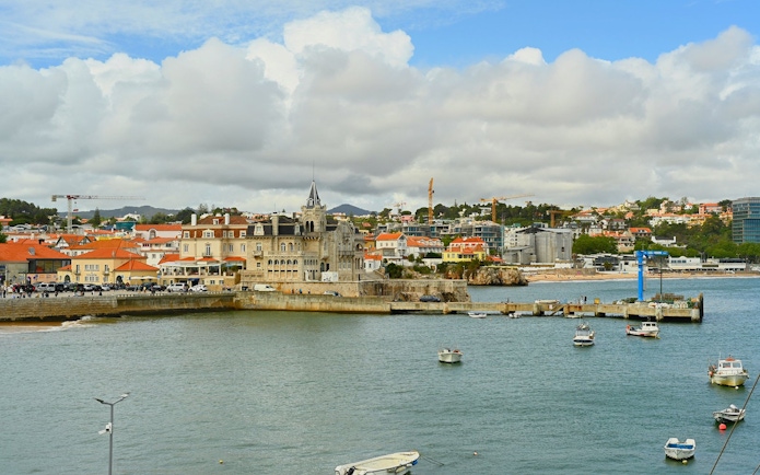 Waterfront view of Cascais with boats and historic buildings along the shore.