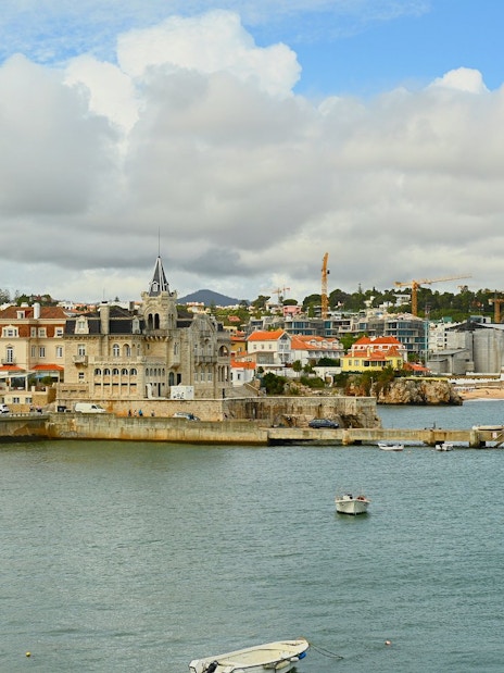 Waterfront view of Cascais with boats and historic buildings along the shore.