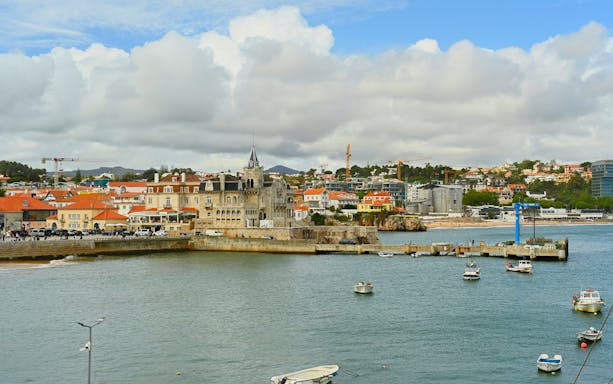 Waterfront view of Cascais with boats and historic buildings along the shore.