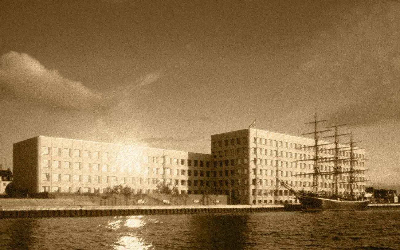 Historic ship docked by modern building in Copenhagen Royal District.