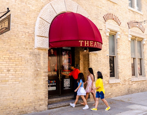 Visitors navigating a colorful mirror maze in San Antonio, Texas.